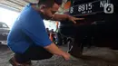 Petugas melakukan uji emisi mobil secara gratis di Bengkel Dinas Lingkungan Hidup DKI Jakarta, Kamis (4/11/2021). Pemprov DKI Jakarta mengumumkan akan menerapkan sanksi tilang bagi kendaraan bermotor yang tidak lulus atau belum melakukan uji emisi. (merdeka.com/Imam Buhori)
