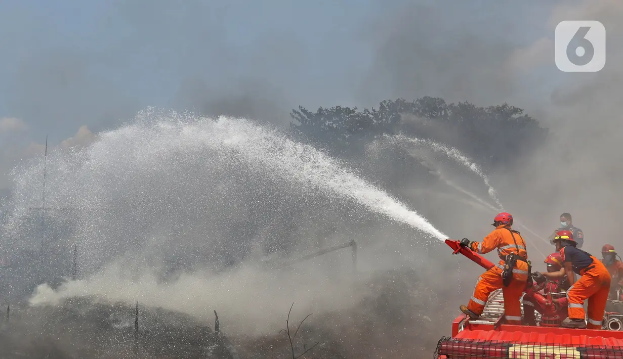Petugas Pemadam Kebakaran Kabupaten Bogor memadamkan api di lapak ban bekas, Desa Bojong Nangka, Gunung Putri, Kamis (22/4/2021). Banyaknya bahan yang mudah terbakar dan sumber api yang berasal dari bawah tumpukan ban membuat  api di lokasi belum juga padam. (Liputan6.com/Herman Zakharia)