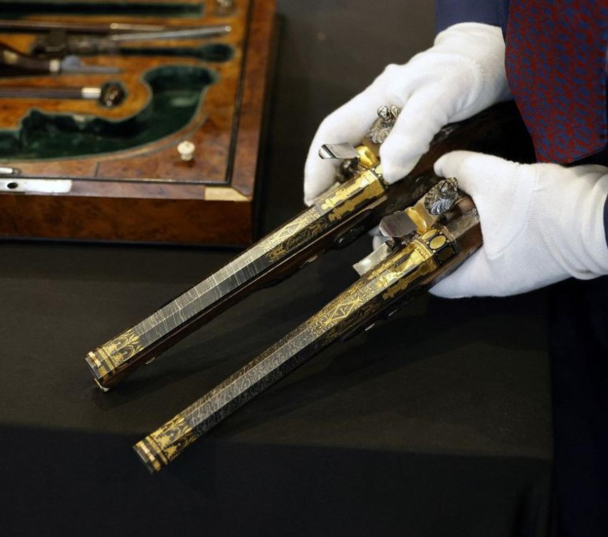 Seorang petugas menunjukkan dua pistol langka milik Kaisar Prancis Napoleon Bonaparte di Paris, Prancis, pada 18 Juni 2024. Sepasang pistol langka, yang dulunya ingin digunakan Napoleon Bonaparte untuk bunuh diri, akan dilelang dan diperkirakan terjual hi