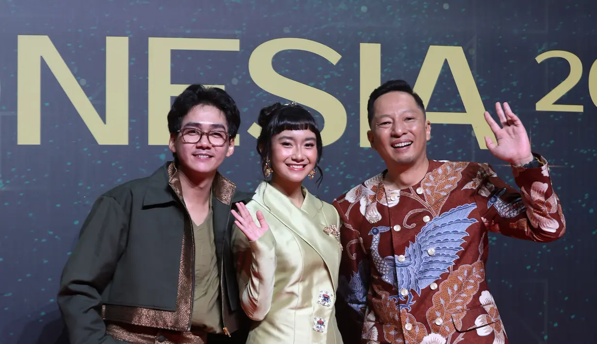 Diapit Chicco Kurniawan dan Ringgo Agus Rahman, Freya JKT48 kenakan kebaya janggan satin panjang. Kebaya emas itu dipadu dengan kain tenun biru yang kontras [Budi Santoso]