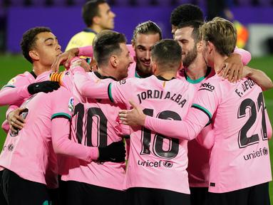 Pemain Barcelona merayakan gol yang dicetak Lionel Messi ke gawang Valladolid pada laga lanjutan Liga Spanyol di Jose Zorrilla Stadium, Rabu (23/12/2020) dini hari WIB. Barcelona menang 3-0 atas Valladolid. (AFP/Cesar Manso)