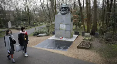 Pengunjung berjalan dekat makam filsuf ternama Jerman dan tokoh sosialisme, Karl Marx, di Pemakaman Highgate, London, Selasa (5/2). Nisan peringatan terbuat dari marmer yang menandakan persemayaman Marx dirusak oleh orang tidak dikenal. (Tolga AKMEN/AFP)