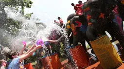 Sejumlah wisatawan asing bermain air bersama gajah saat perayaan tahun baru kuno Thailand atau Songkran di provinsi Ayutthaya, Thailand (11/4). Songkran sudah menjadi festival dan event wisata di Thailand. (AP Photo/Sakchai Lalit)