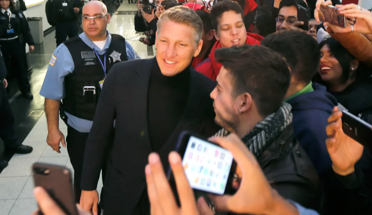 Para penggemar menyambut kedatangan mantan gelandang Manchester United, Bastian Schweinsteiger di Bandara Internasional O'Hare, Chicago, Selasa (28/3). Kedatangan Schweinsteiger untuk bergabung dengan klub MLS, Chicago Fire (AP Photo/Charles Rex Arbogast)