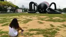 Seorang wanita melihat balon laba-laba raksasa di kawasan Marina Bay, Singapura, Senin (6/2). Balon buatan seniman Singapura Jackson Tan tersebut dibuat untuk memeriahkan acara festival cahaya di Singapura. (AFP PHOTO / ROSLAN RAHMAN)