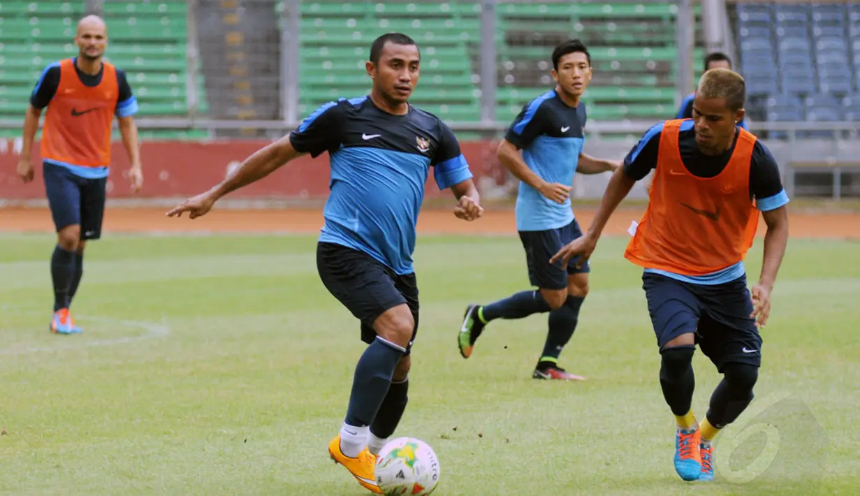 Firman Utina (kedua dari kiri) berusaha melewati hadangan Manahati Lestusen saat berlatih bersama timnas Indonesia di Stadion GBK Jakarta, Kamis (13/11/2014). (Liputan6.com/Helmi Fithriansyah)