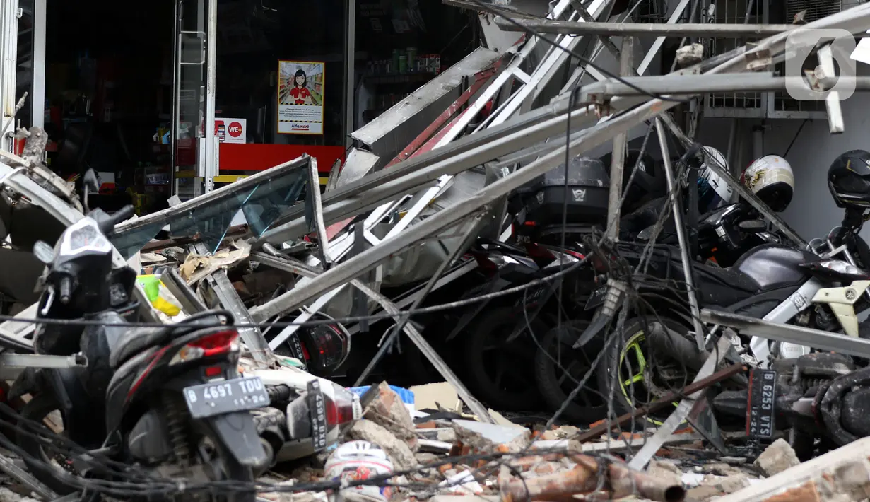 Sejumlah sepeda motor tertimpa gedung yang ambruk di Jalan Brigjen Katamso, Kota Bambu Selatan, Palmerah, Jakarta Barat, Senin (6/1/2020). Tiga orang dilaporkan terluka akibat tertima material gedung empat lantai tersebut. (Liputan6.com/Johan Tallo)