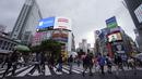 Orang-orang mengenakan masker untuk mencegah virus corona berjalan melintasi penyeberangan pejalan kaki pada awal liburan "Minggu Emas" Jepang di distrik Shibuya, Tokyo, Kamis (29/4/2021). Pemerintah Jepang meminta warga untuk tinggal di rumah selama "minggu emas". (AP Photo/Eugene Hoshiko)