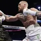 Serangan Conor McGregor (kanan) yang mampu diblok Floyd Mayweather Jr. pada gelaran Tinju Dunia super welterweight boxing di MGM Arena, Las Vegas, (26/8/2017). Mayweather menang TKO atas McGregor. (AP/Isaac Brekken)