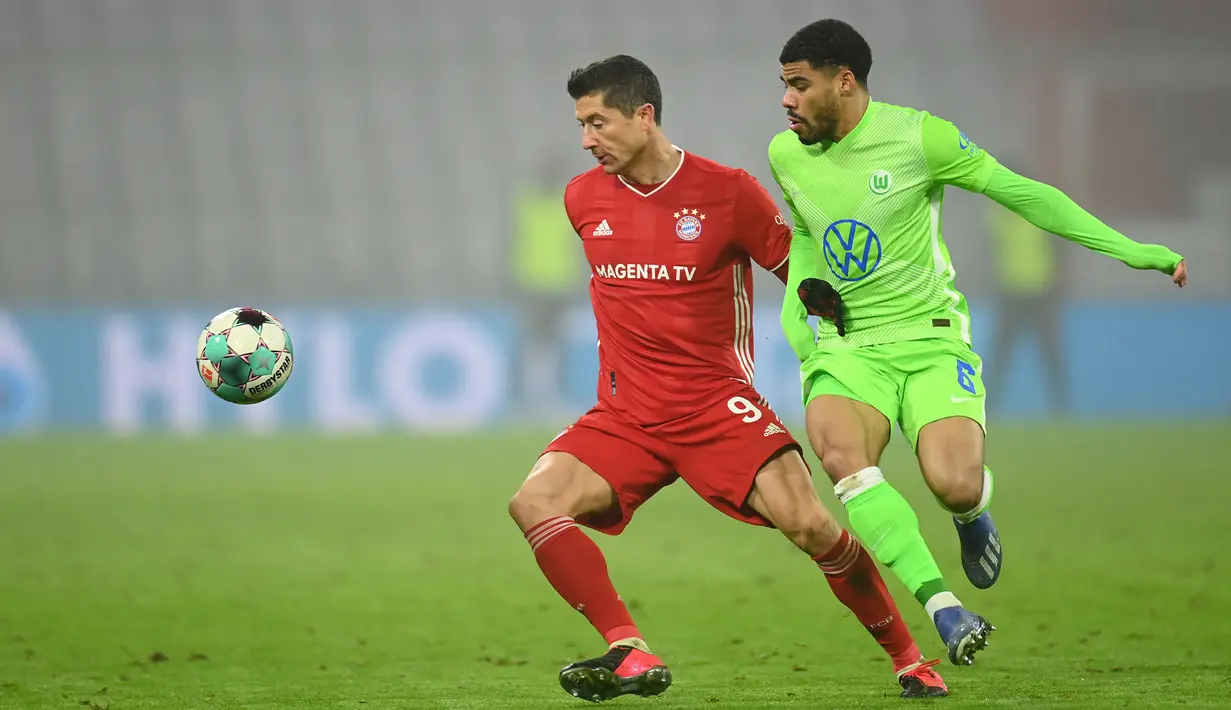 Penyerang Bayern Munchen, Robert Lewandowski, berebut bola dengan bek Wolfsburg, Paulo Otavio, pada laga lanjutan Liga Jerman di Allianz Arena, Kamis (17/12/2020) dini hari WIB. Bayern Munchen menang 2-1 atas Wolfsburg. (AFP/Christof Stache/pool)