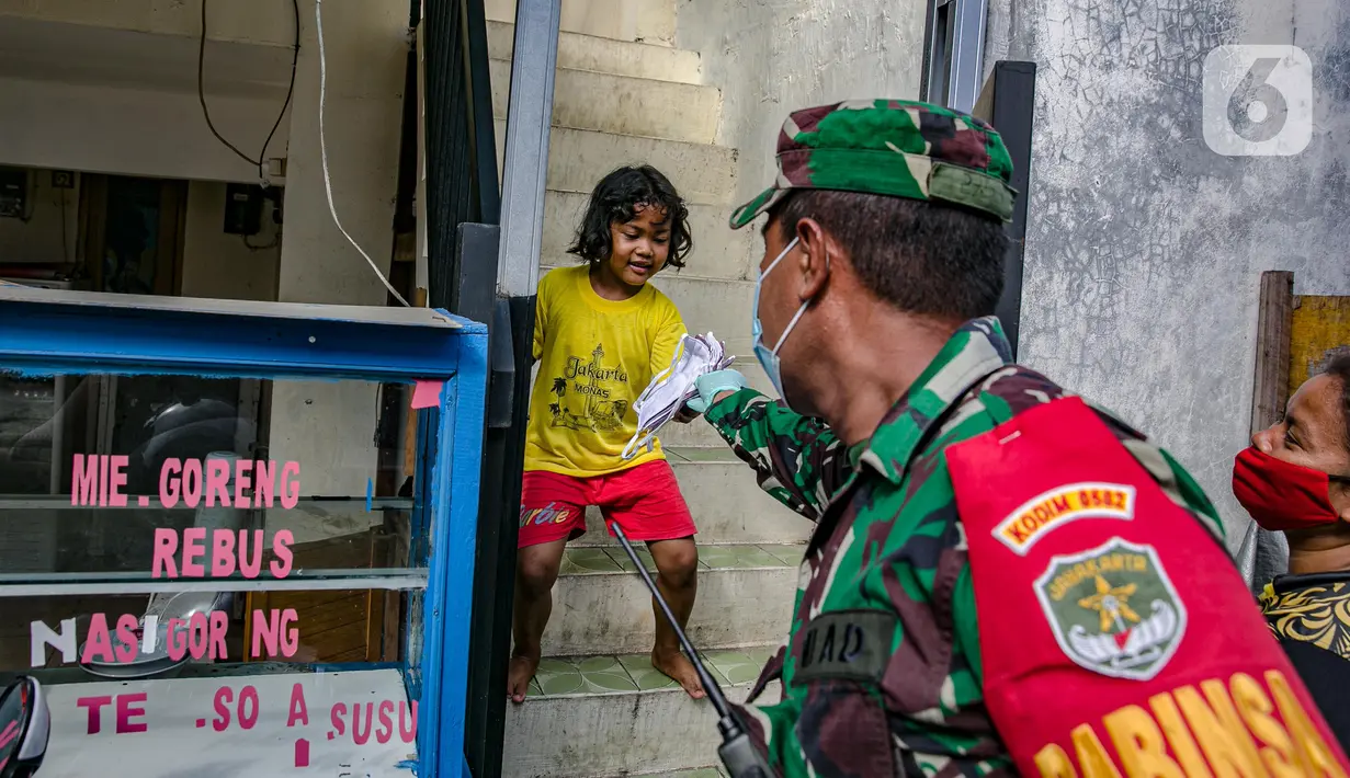 Anggotan TNI membagika masker kepada anak-anak di Sunter Muara, Tanjung Priok, Jakarta, Selasa (9/2/2021). Tujuan kegiatan tersebut agar masyarakat menyadari peran penting penggunaan masker dalam memutus mata rantai penyebaran COVID-19. (Liputan6.com/Faizal Fanani)