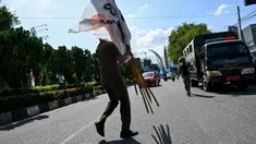 Anggota Satpol PP menertibkan alat peraga kampanye (APK) Pemilu 2024 di kawasan terlarang di Banda Aceh, Aceh, Kamis (11/1/2024). Penertiban ini dilakukan menjelang pemilu yang dijadwalkan digelar pada 14 Februari. (CHAIDEER MAHYUDDIN/AFP)