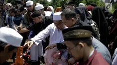 Penyanyi religi Opick menaburkan bunga usai memakamkan almarhum istri keduanya Wulan Mayasari di TPU Semper, Jakarta, Senin (19/3). Diiringi shalawat nabi dan tahlil, Opick memakamkan istrinya dengan wajah yang tegar. (Liputan6.com/Faizal Fanani)