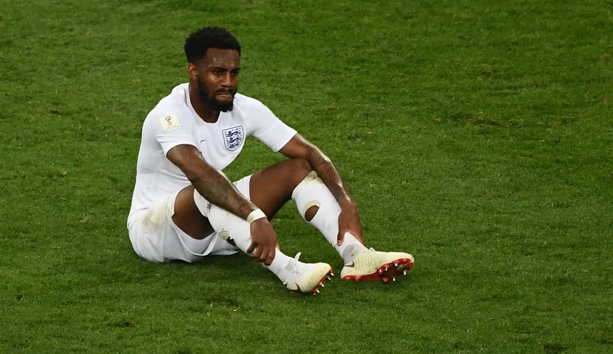 Bek timnas Inggris, Danny Rose terlihat kecewa sambil duduk di lapangan seusai babak semifinal Piala Dunia 2018 melawan Kroasia di Stadion Luzhniki, Rabu (11/7). Rose menyita perhatian lantaran mengenakan kaus kaki yang berlubang. (AFP/ Jewel SAMAD)