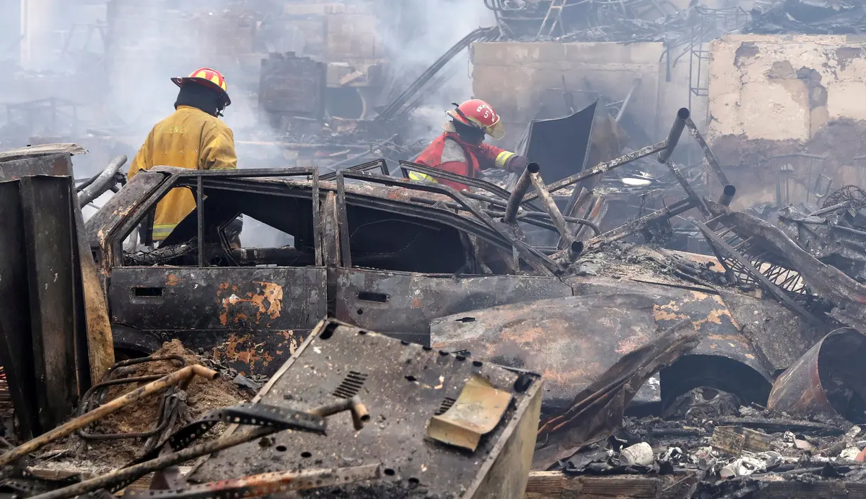 Petugas pemadam memeriksa lokasi kebakaran besar yang melanda permukiman Cantagallo di Lima, Peru, Jumat (4/11). Kebakaran mengakibatkan sekitar 300 rumah rata dengan tanah dan memaksa ribuan warganya mengungsi. (REUTERS/Guadalupe Pardo)