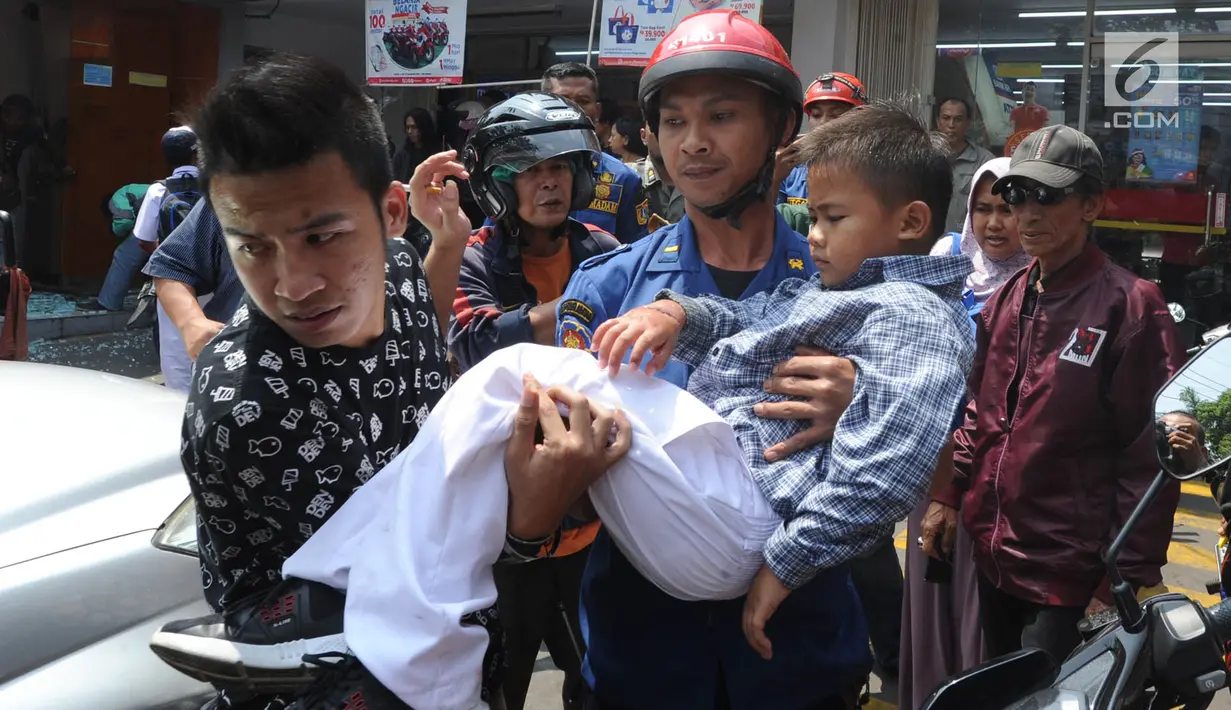Petugas Damkar dari Pos Pesanggrahan membawa murid TK, Fathur  usai menyelamatkannya dari terjepit kaca pintu ATM Bank BNI di Jalan M. Saidi, pesanggrahan, Jakarta Selatan, Senin (5/8/2019). Fathur mengalami luka pada tanggannya selanjutnya dibawa ke rumah sakit. (merdeka.com/Arie Basuki)