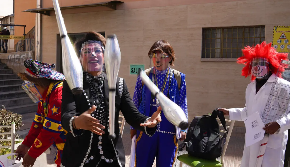 Para badut menghibur orang-orang yang menunggu untuk mendapatkan suntikan vaksin COVID-19 Sinopharm selama kampanye vaksinasi yang menargetkan usia antara 18 dan 30 tahun di Universitas Negeri San Andres di La Paz, Bolivia, Senin (5/7/2021). (AP Photo/Juan Karita)