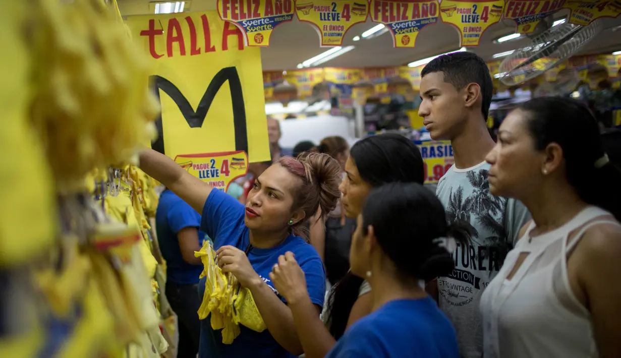 Seorang wanita memilih celana dalam berwarna kuning di Medellin, Kolombia, Jumat (29/12). Di Kolombia, tradisi mengenakan celana dalam berwarna kuning saat malam Tahun Baru dianggap dapat membawa kemakmuran dan keberuntungan. (Joaquin SARMIENTO / AFP)