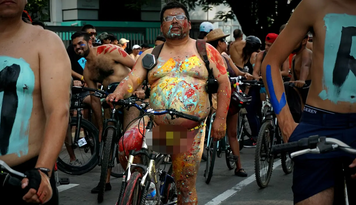 Seorang pria mengendarai sepeda dengan tubuh di cat serta telanjang saat mengikuti World Naked Bike Ride di Guadalajara, Jalisco, Meksiko (17/6). (AFP Photo/Hector Guerrero)