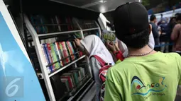 Sejumlah pelajar memilih buku di Mobil Pintar Ancol usai peluncurannya di Ancol, Jakarta, Rabu (15/6/2016). Mobil tersebut disediakan di pemukiman padat penduduk dengan kegiatan bermain lebih banyak dari pada kegiatan belajar. (Liputan6.com/Faizal Fanani)