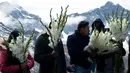 Orang-orang memegang bunga untuk persembahan ritual Pachamama atau Ibu Bumi di gunung La Cumbre, pinggiran La Paz, Bolivia, Rabu (1/8). Bulan Agustus adalah saat dimana melakukan persembahan menghormati dewi bumi dan meminta keberuntungan (AP/Juan Karita)