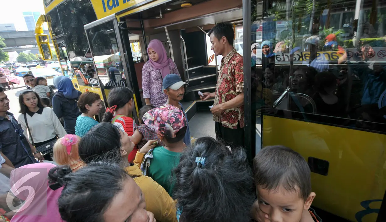Warga saat menaiki bus tingkat City Tour Wisata Keliling Jakarta di halte Istiqlal, Jakarta, Kamis (7/7). Sejumlah warga memanfaatkan fasilitas bus wisata gratis untuk berkeliling Jakarta bersama keluarga. (Liputan6.com/Yoppy Renato)