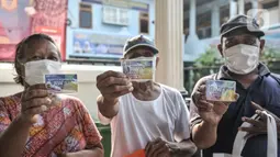 Warga lansia menunjukkan kartu ATM Beras saat menerima bantuan di Kantor RW 02, Kelurahan Cilincing, Jakarta Utara, Rabu (17/3/2021).  Pembuatan ATM Beras secara mandiri sebagai program ketahanan pangan di masa pandemi Covid-19. (merdeka.com/Iqbal S. Nugroho)