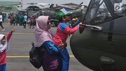 Seorang siswa memegang helikopter pmilik TNI AD ada pameran alat utama sistem persenjataan (Alutsista) di Lanumad  Ahmad Yani Semarang, Jumat (5/10). Pameran alutsista tersebut dalam rangka memeriahkan HUT Ke-73 TNI. (Liputan6.com/Gholib)