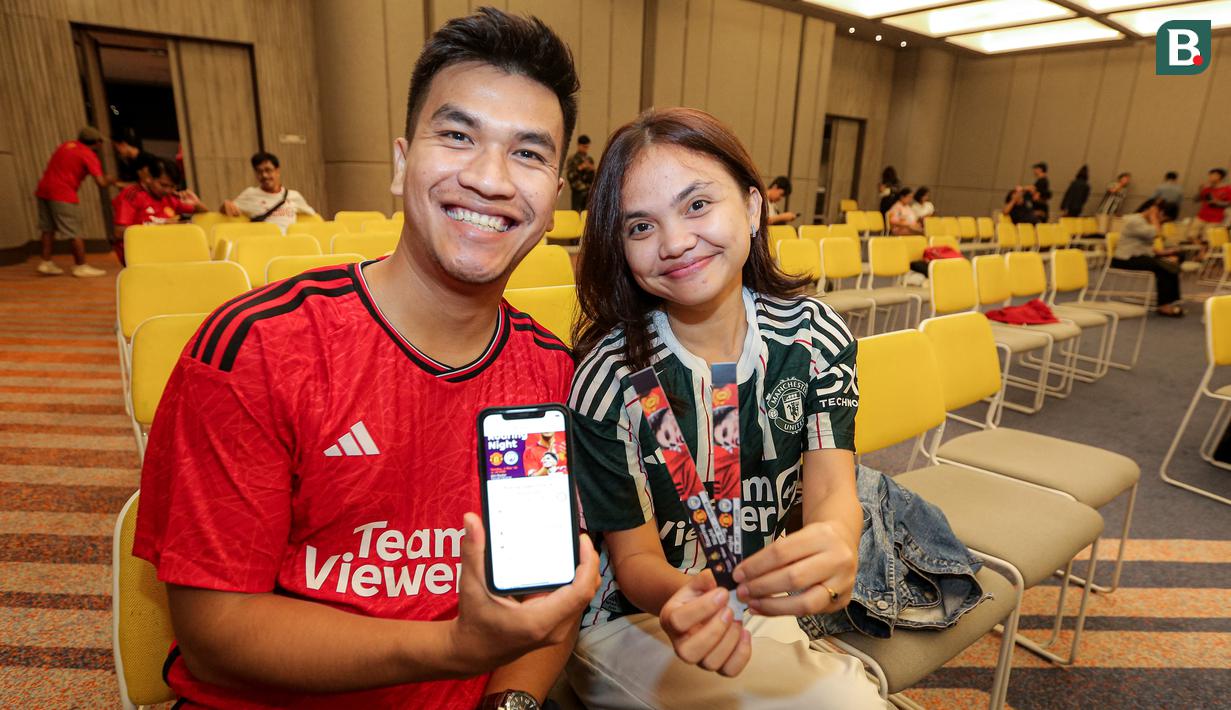 <p>Sepasang fans MU memperlihatkan tiket pembelian Roaring Night Liga Inggris antara Manchester City melawan Manchester United yang berlangsung di Hotel IBIS Style, Tanah Abang, Jakarta, Minggu (03/03/2024). (Bola.com/Bagaskara Lazuardi)</p>