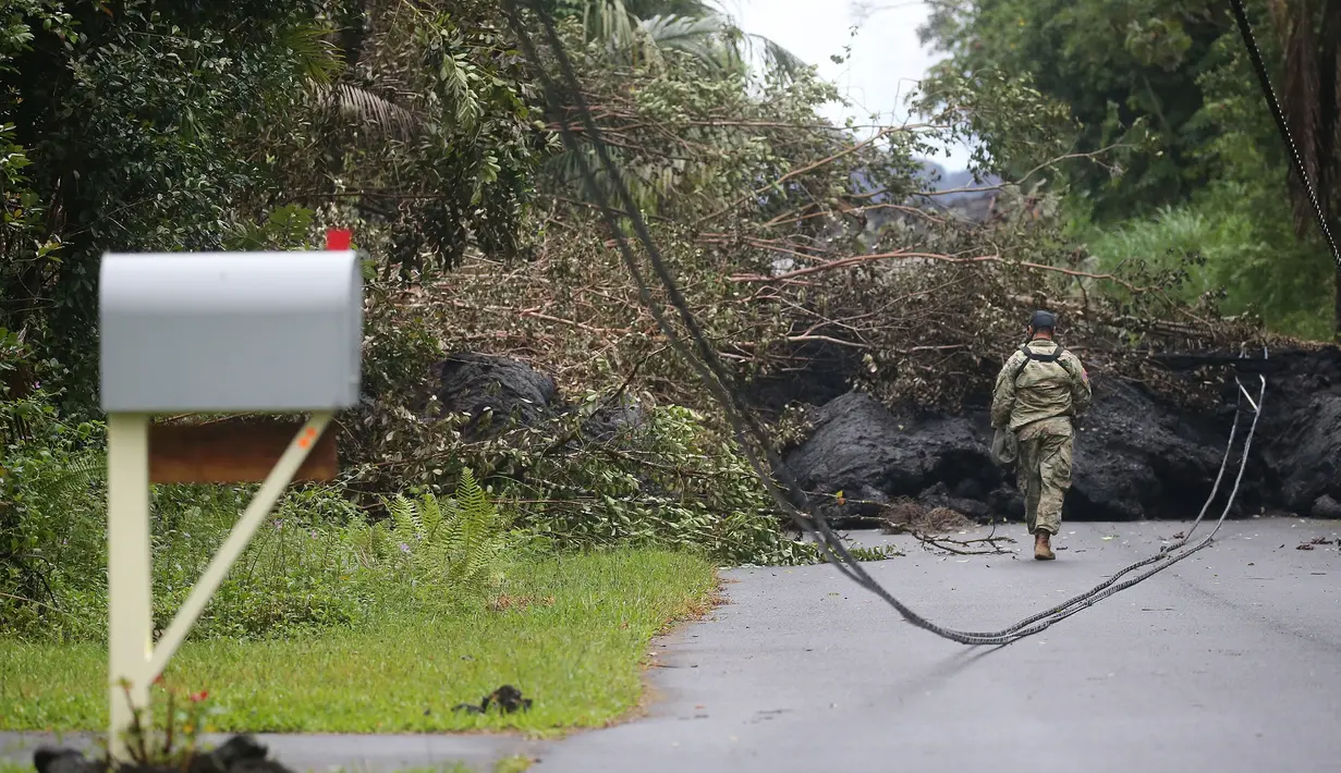Garda Nasional Angkatan Darat AS memeriksa lahar dingin setelah letusan yang terjadi pada gunung berapi Kilauea di Hawaii (8/5). Gunung api tersebut telah memuntahkan lava dan gas sulfur dioksida dalam jumlah besar. (Mario Tama / Getty Images / AFP)