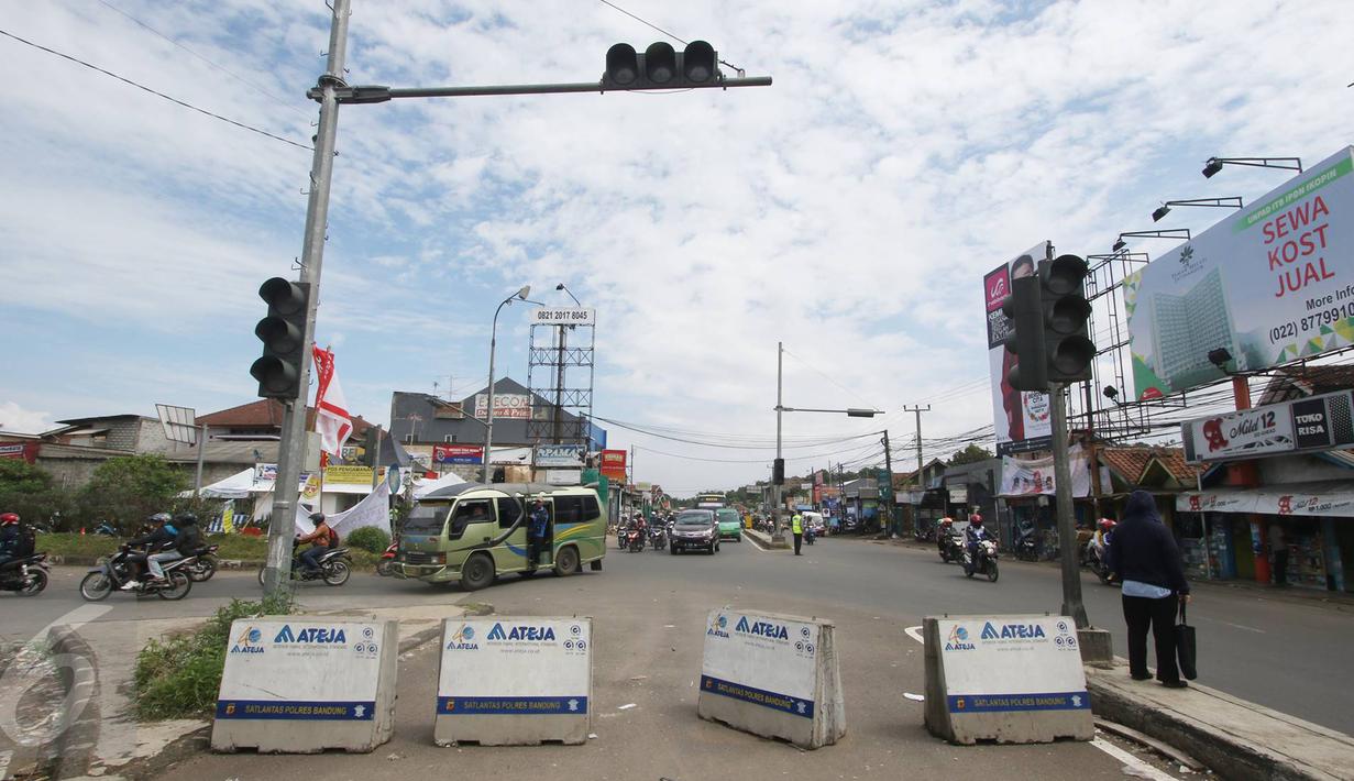 Kendaraan melintas di pertigaan Jatinangor, Sumedang, Jawa Barat, Sabtu (2/7). Mengatasi kepadatan kendaraan pemudik, petugas melakukan sistem pengalihan arus dengan menutup jalur dari arah Sumedang menuju Bandung Kota. (Liputan6.com/Immanuel Antonius)