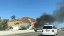 Kendaraan melintas di dekat pesawat antik Amerika Utara AT-6 yang terbakar di US 101 di Agoura Hills, California (23/10). AFP Photo/Cynthia Alvarez)