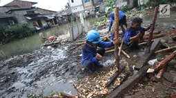 Pekerja menyelesaikan pembuatan tanggul darurat di kawasan Jatipadang, Jakarta, Rabu (22/11). Akibat banjir ini, warga yang terdampak semalam diungsikan sementara ke sebuah masjid di dekat lokasi. (Liputan6.com/Immanuel Antonius)