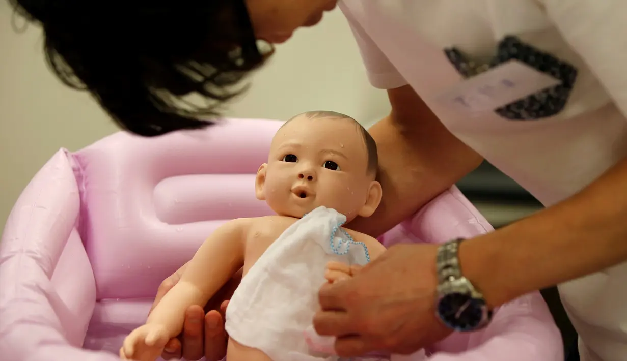 Sejumlah pria mengikuti "Ikumen", kursus mengasuh bayi yang diselenggarakan oleh sebuah perusahaan yang berbasis di Osaka, Tokyo, Jepang (18/9). Kursus ini untuk memberikan pengajaran cara mengasuh bayi yang benar kepada kaum pria. (REUTERS/Issei Kato)