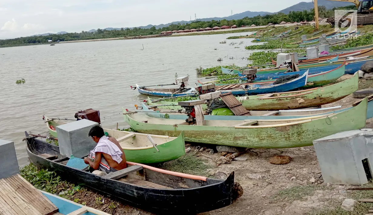 Seorang nelayan beraktivitas di dekat perahu yang bersandar di Danau Limboto, Gorontalo (20/12). Meskipun saat ini musim penghujan, Debit air Danau Limboto makin hari makin berkurang. (Liputan6.com/Arfandi Ibrahim)