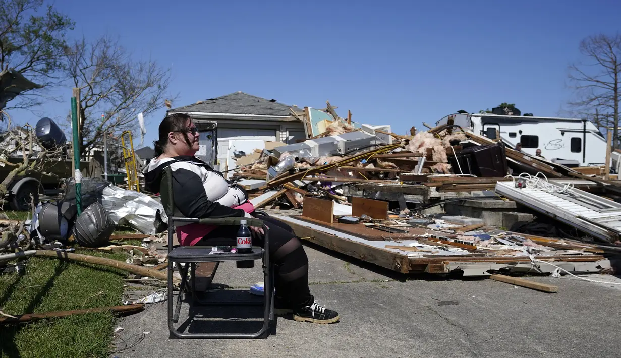 Bonnie Norris, yang selamat di dalam rumahnya, duduk di luar rumahnya yang hancur setelah tornado melanda daerah di Arabi, La., Rabu (23/3/2022). (AP Photo/Gerald Herbert)