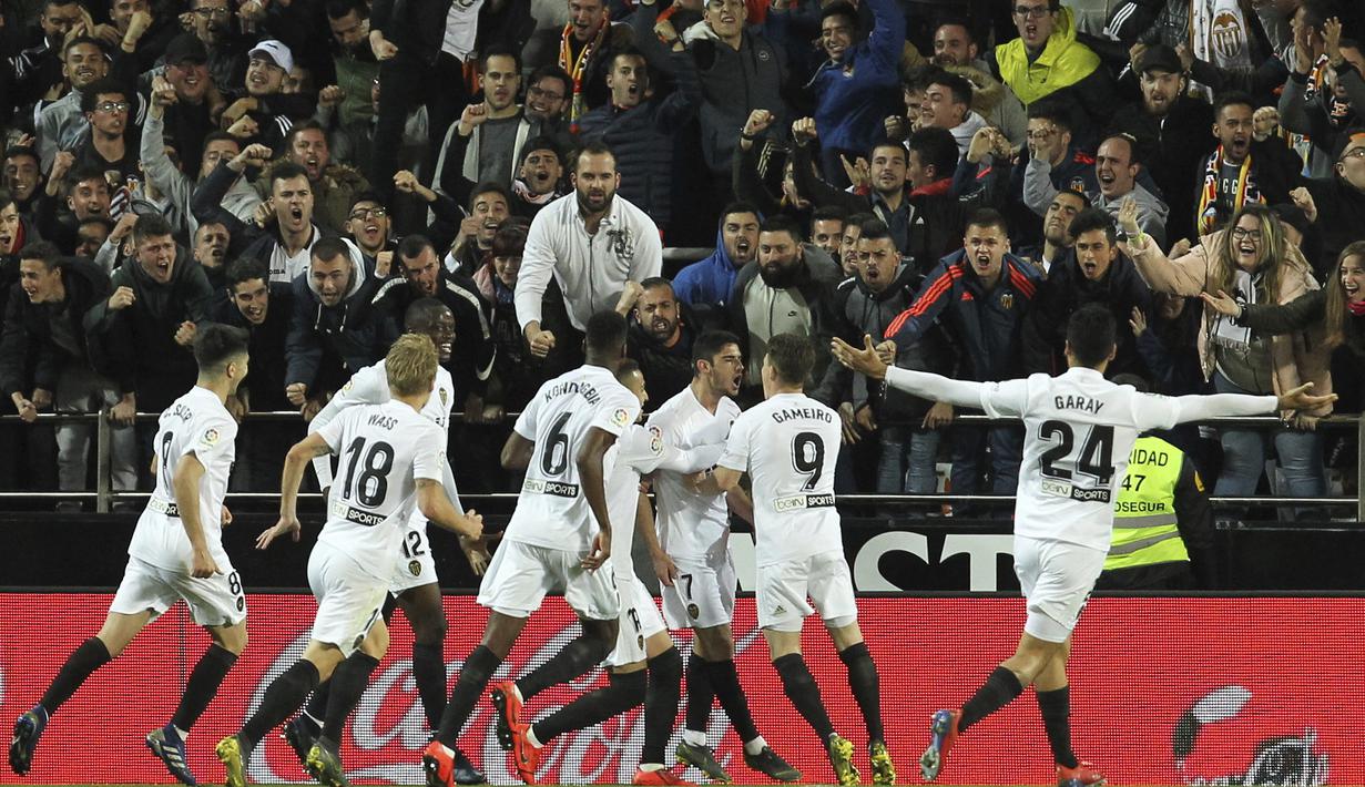 Para pemain Valencia merayakan gol yang dicetak oleh  Goncalo Guedes ke gawang Real Madrid pada laga La Liga 2019 di Stadion Mestalla, Rabu (3/4). Valencia menang 2-1 atas Real Madrid. (AP/Alberto Saiz)