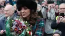 Kate Middleton menggenggam buket bunga setelah tradisi kebaktian Hari Natal Kerajaan Inggris di Gereja St. Mary Magdalene, Sandringham, Senin (25/12). Pea coat yang dipakai Kate Middleton terbuat dari bahan velvet seharga Rp 48,12 juta (AP/Alastair Grant)