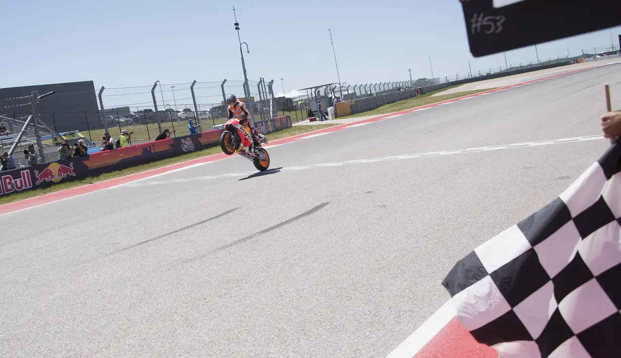 Marc Marquez mengangkat motornya setelah berhasil finish diurutan pertama pada MotoGP Amerika di Austin, Texas, (23/4). Valentino Rossi meraih Posisi kedua dan posisi ketiga ditempati Dani Pederosa. (Getty Images/Getty Images/AFP)