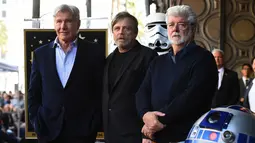 Mark Hamill (tengah) berfoto bersama Harrison Ford (kiri) dan George Lucas (kanan) saat dianugerahi Hollywood Walk of Fame di Los Angeles (8/3). Yang menarik, seremoni acara dilakukan dengan tema Star Wars. (Jordan Strauss / Invision / AP)