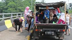 Warga menumpang kendaraan bak terbuka untuk menuju Kebun Binatang Ragunan di kawasan Jakarta, Minggu (9/6/2019). Masyarakat memanfaatkan truk dan mobil bak terbuka untuk bepergian saat libur lebaran karena dianggap lebih hemat biaya. (Liputan6.com/Herman Zakharia)