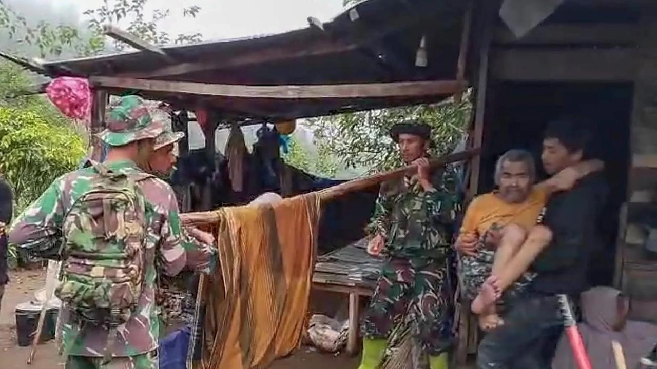 Anggota Koramil 05/Permata TNI AD mengevakuasi sepasang lansia dari wilayah terisolir menuju Puskesmas Buntul di Gucci Desa Burni Pase, Kecamatan Permata, Kabupaten Bener Meriah, Kamis (11/12/2025).