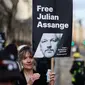Seorang demonstran memegang plakat bergambar pendiri WikiLeaks, Julian Assange dalam sebuah protes di luar Royal Courts of Justice, Pengadilan Tinggi Inggris, di pusat kota London, pada tanggal 20 Februari 2024. (Daniel LEAL/AFP)