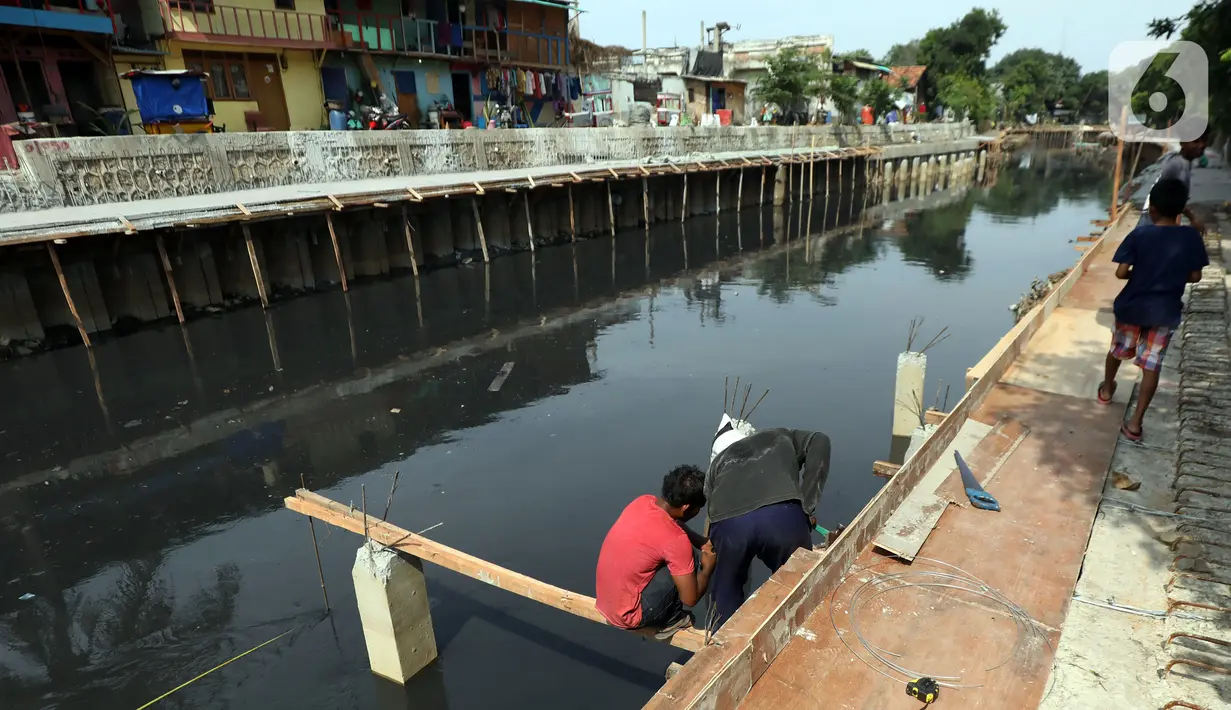 Pekerja mengerjakan proyek pembangunan tanggul bantaran Kali Anak Ciliwung di RT 001 RW 008 Ancol, Pademangan, Jakarta Utara, Kamis (19/12/2019). Pembangunan tanggul untuk mencegah amblesnya bantaran sungai seperti pada akhir tahun 2018 lalu. (Liputan6.com/Johan Tallo)