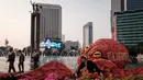 <p>Polisi berjalan melewati sosok berbentuk gurita yang memegang manekin yang menyerupai seorang bakal calon presiden pada pemilu 2024 mendatang di kawasan Bundaran Hotel Indonesia, Jakarta, Jumat (6/10/2023). (Yasuyoshi CHIBA/AFP)</p>