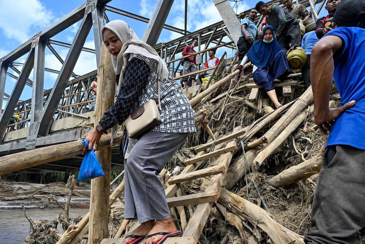 FOTO: Warga Memanjat Puing Kayu Demi Menyeberangi Sungai Peusangan