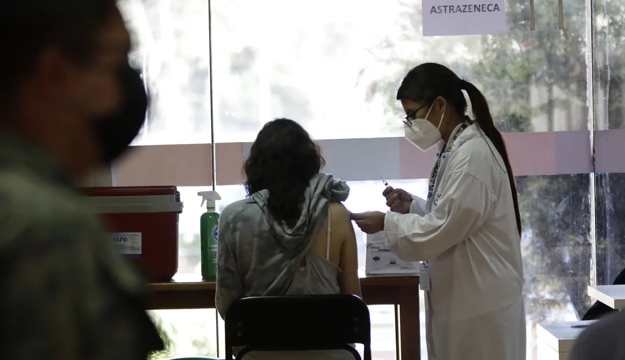 Seorang perempuan mendapat suntikan vaksin COVID-19, di Quito, Ekuador, Kamis (24/12/2021). Pemerintah Ekuador telah menyatakan vaksinasi COVID-19 wajib setelah meningkatnya infeksi dan munculnya varian baru virus corona. (AP Photo/Carlos Noriega)