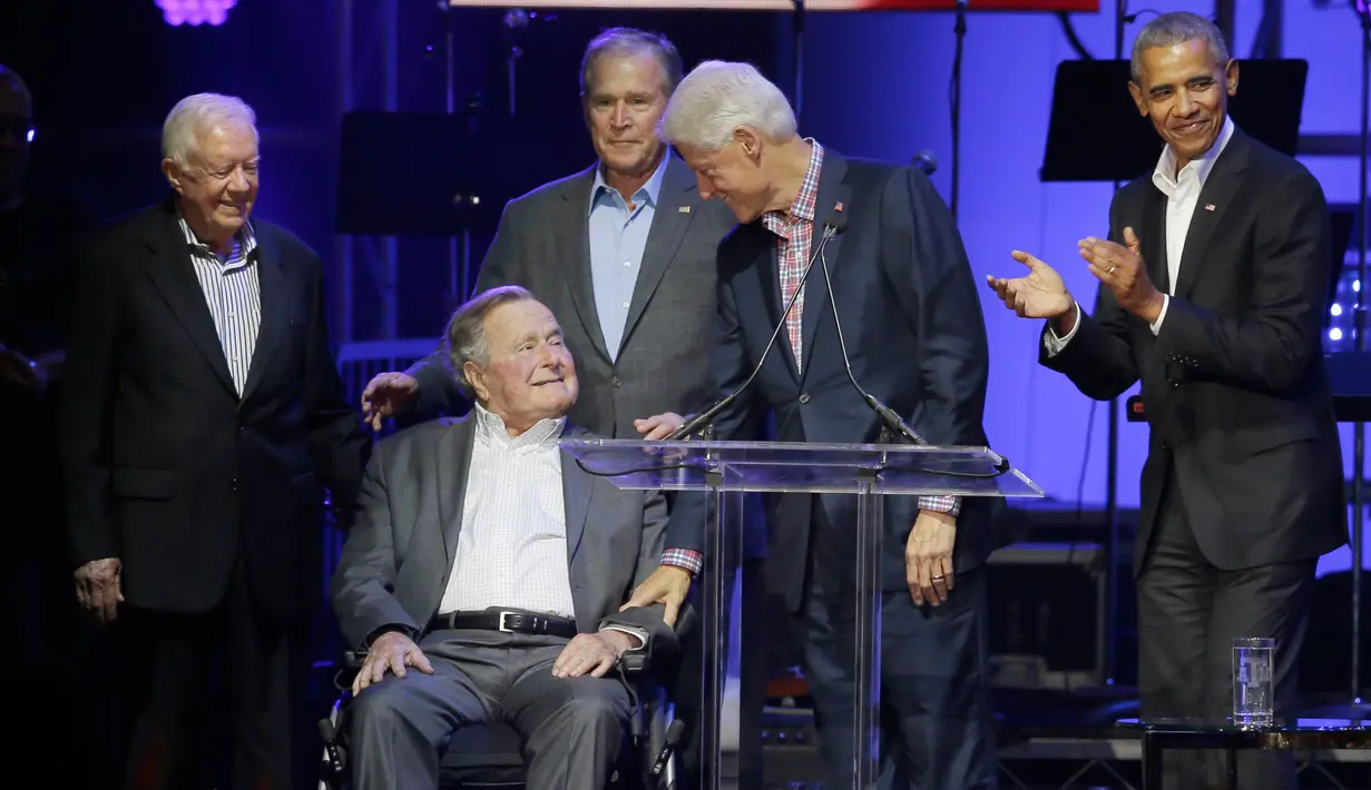 Mantan Presiden Bill Clinton berbincang dengan George H.W. Bush saat berada diatas panggung dalam acara konser amal di College Station, Texas (21/10). (AP Photo/LM Otero)