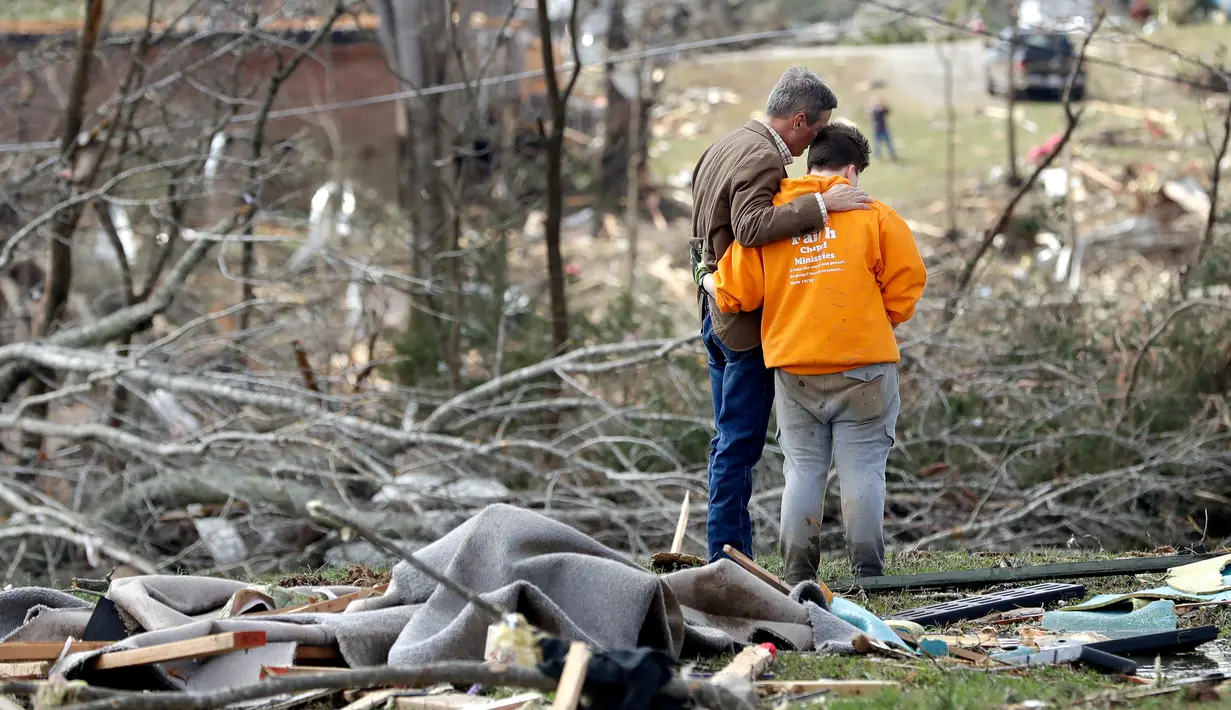 Gubernur Tennessee Bill Lee (kiri) berdoa bersama Kayla Cowen yang sedang mencari tetangganya setelah tornado menerjang Cookeville, Tennessee, Amerika Serikat, Selasa (3/3/2020). Tornado yang menerjang Tennessee menewaskan 25 orang. (AP Photo/Mark Humphrey)