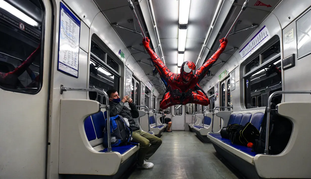 Penari underground yang mengenakan kostum Spiderman tampil di kereta bawah tanah Saint Petersburg, Rusia pada 21 Mei 2021. Penari berkostum Spiderman tersebut tampil berjungkir, melompat dan melakukan gerakan akrobatik di kabin kereta bawah tanah. (Olga MALTSEVA / AFP)